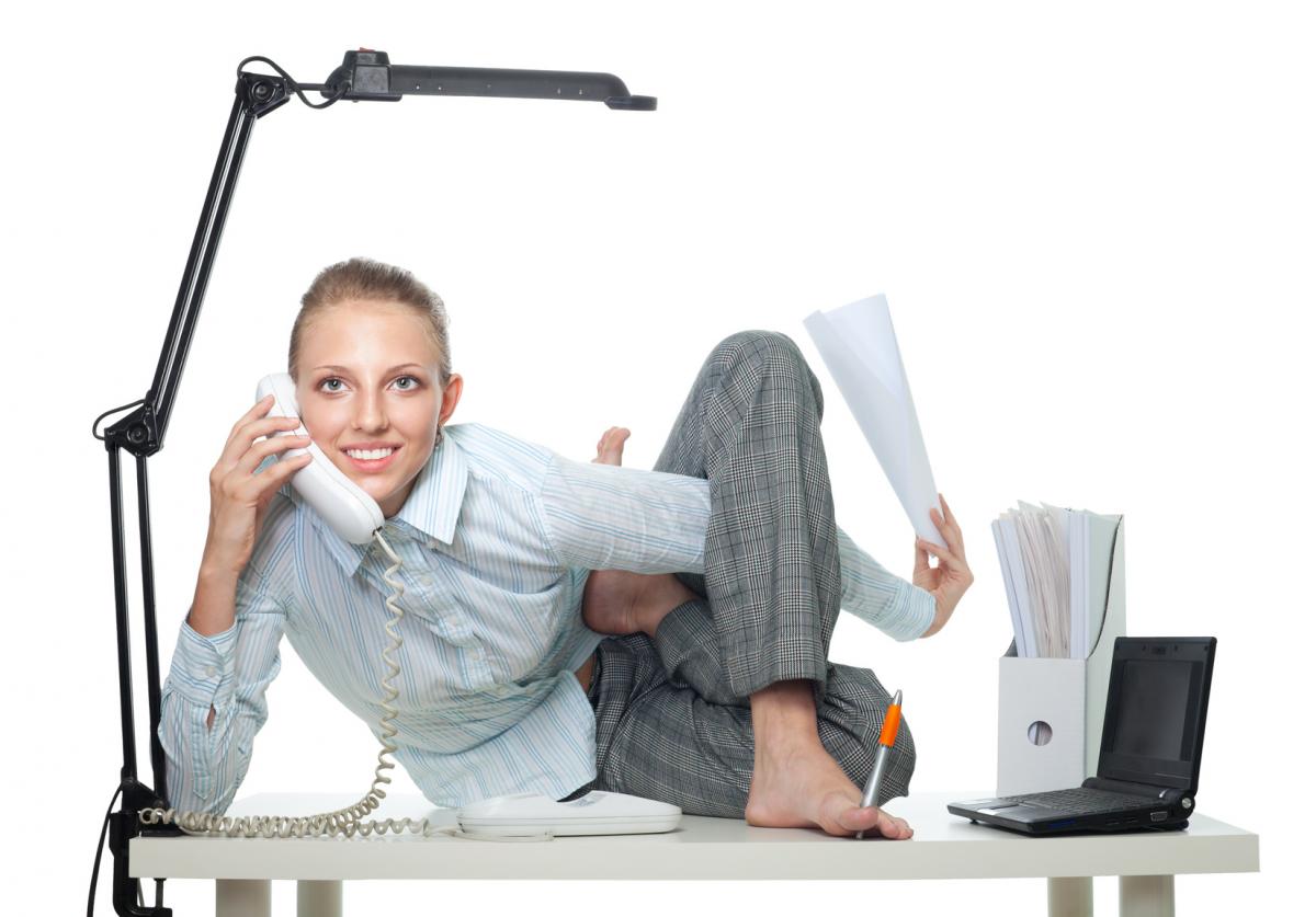 Woman doing Yoga on her desk while on the phone